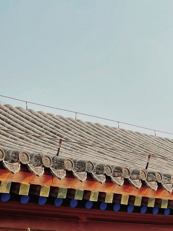 A close-up view of a traditional Chinese roof with detailed tiles in Beijing, China.